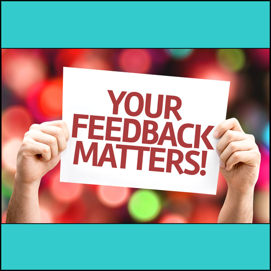 a person's hnds holding up a sign stating "Your feedback matters!"