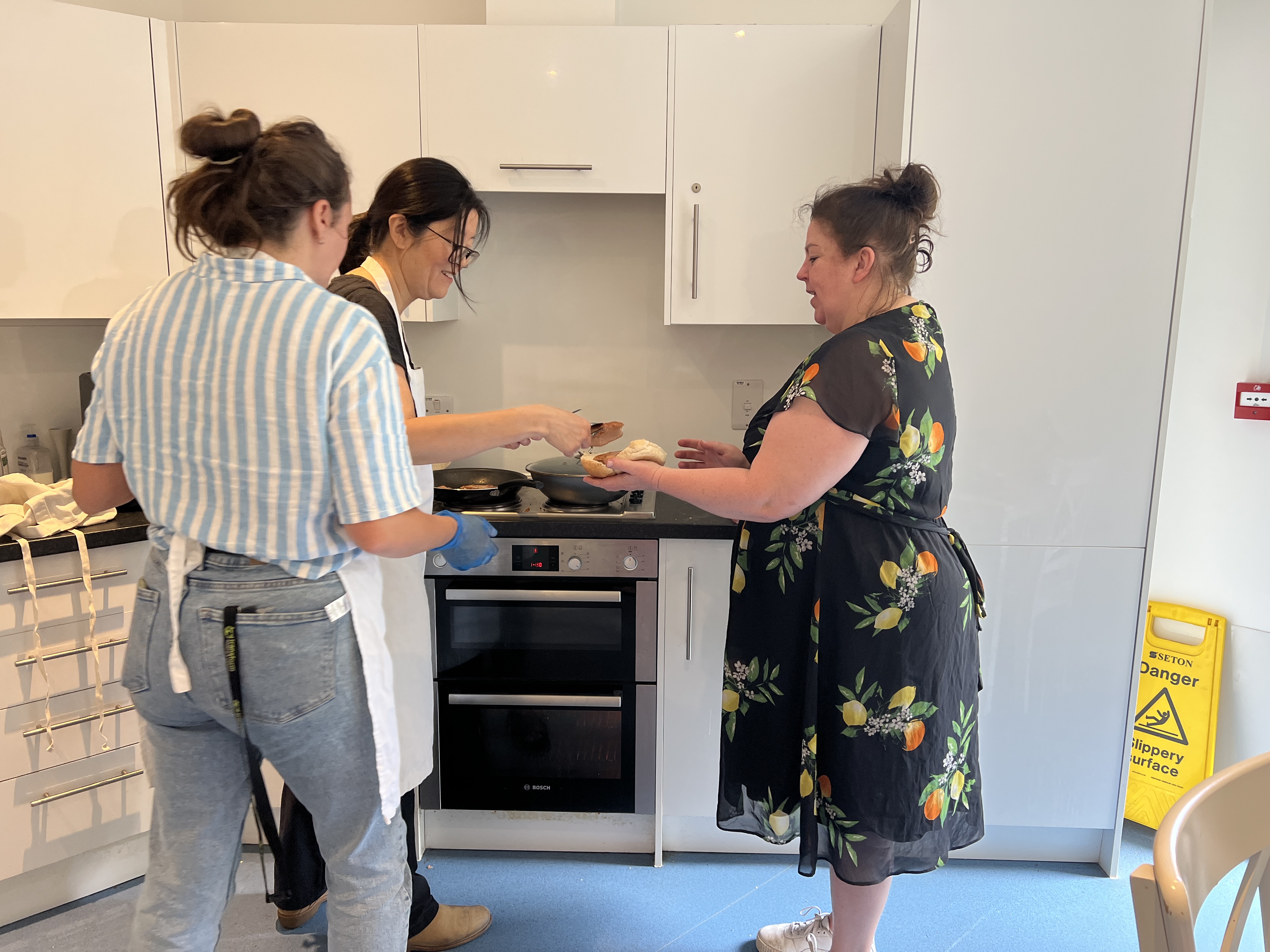 Colleagues teaching staff to cook
