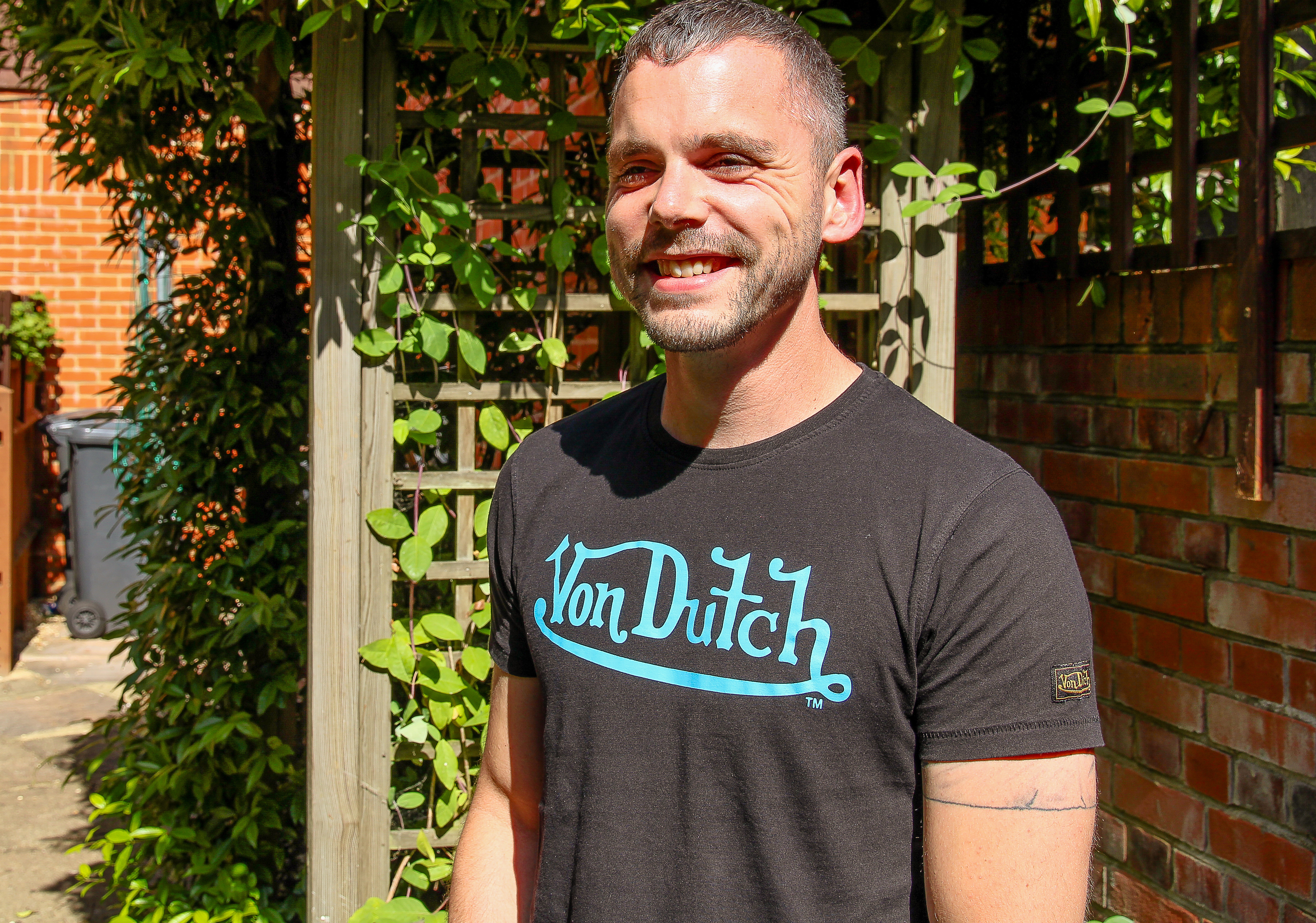A male client standing in a garden