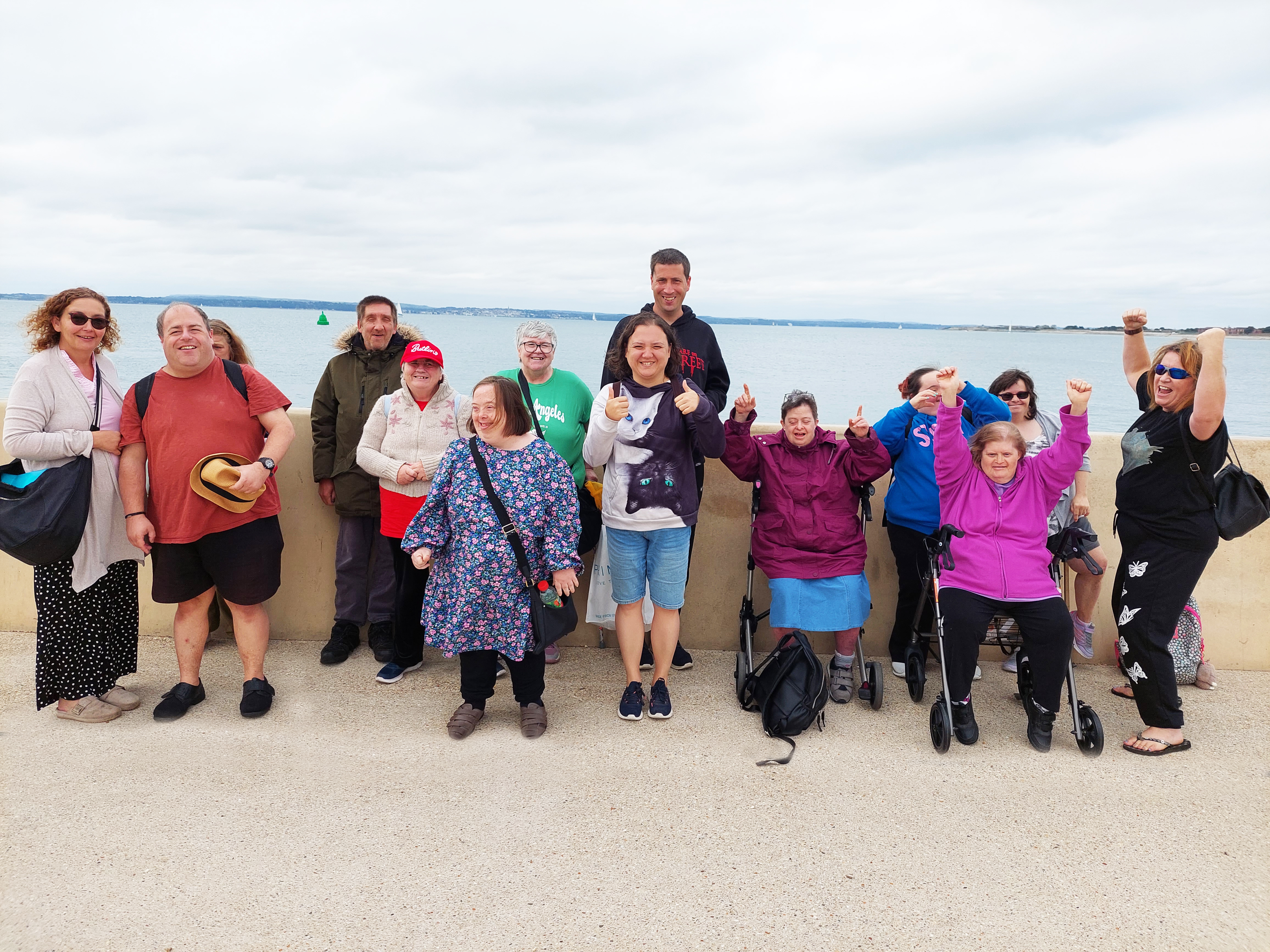 A group of male and female clients and staff at the beach 