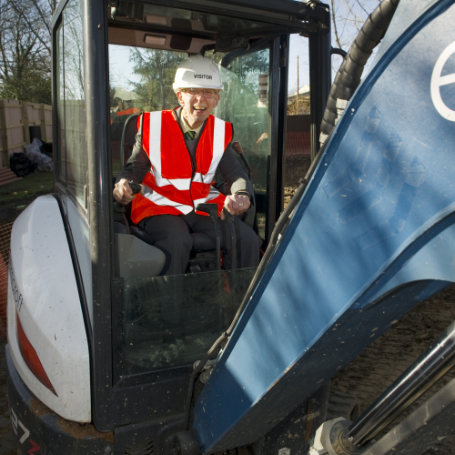 Former Transform CEO Paul Mitchell on a digger at Mitchell Court ground breaking